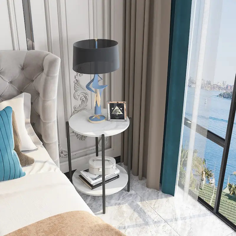 Table d'appoint ronde à deux niveaux en marbre, structure en métal noir.